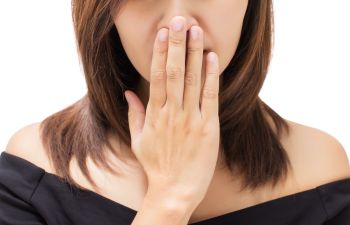 Woman touching her mouth with her hand.