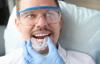 Dentist trying on nightguard for man patient