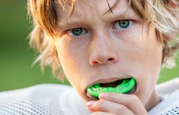 Boy putting in his athletic mouth guard.