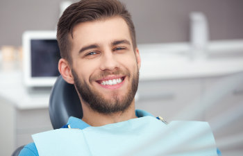 young man happy in the dentist chair